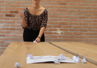 Gif animé une femme jette des boules de papier sur une feuille qui recouvre un smartphone