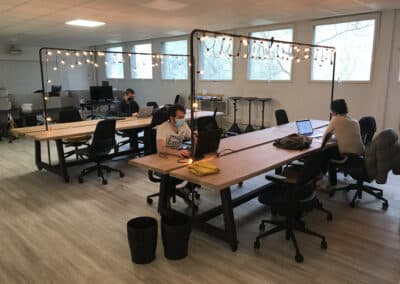 Des étudiants travaillent en autonomie sur leur ordinateur sur des tables en bois dans une vaste pièce du CEP