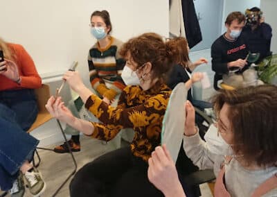 Des étudiants portant un masque sont assis et manipulent des objets