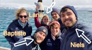 Groupe d'étudiant qui se prend en selfie devant un iceberg sur la mer