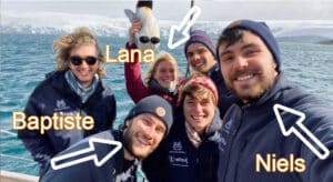 Groupe d'étudiant qui se prend en selfie devant un iceberg sur la mer